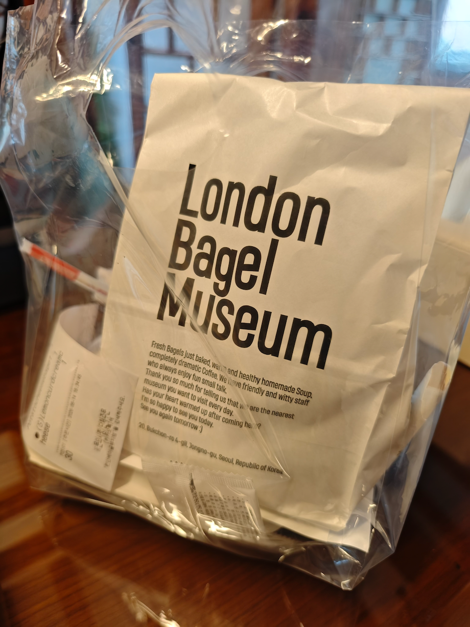 London Bagel Museum 牛皮纸袋，桌上还放着笔和小票
