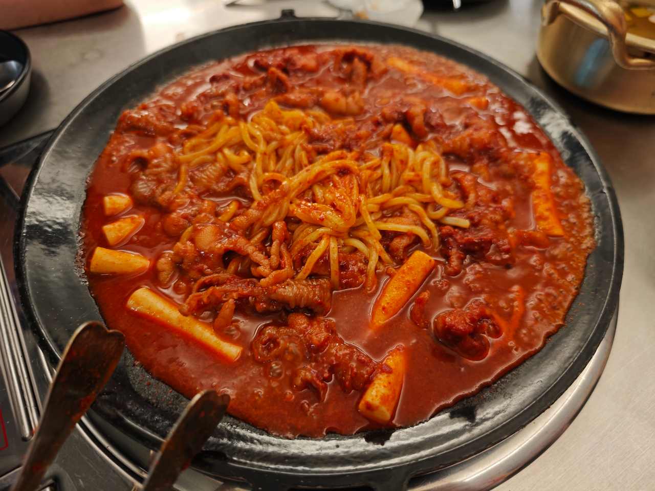 一盘红辣辣的炒菜，年糕和肉片混在红汤里